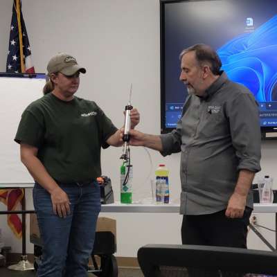 A Continuing Education instructor showing a student how to use Atmospheric Testing equipment.